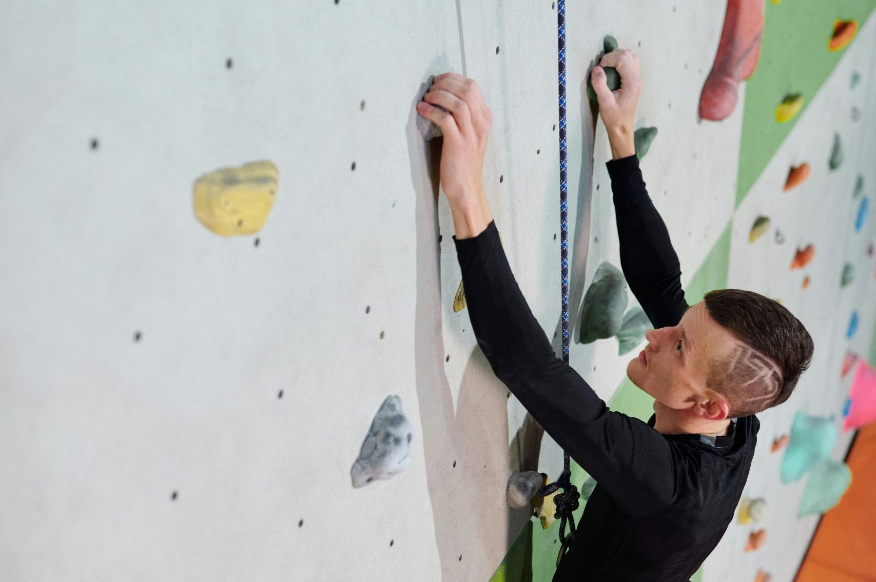 A person climbing an indoor rock wall, symbolising the determination and creativity needed to overcome ADHD challenges