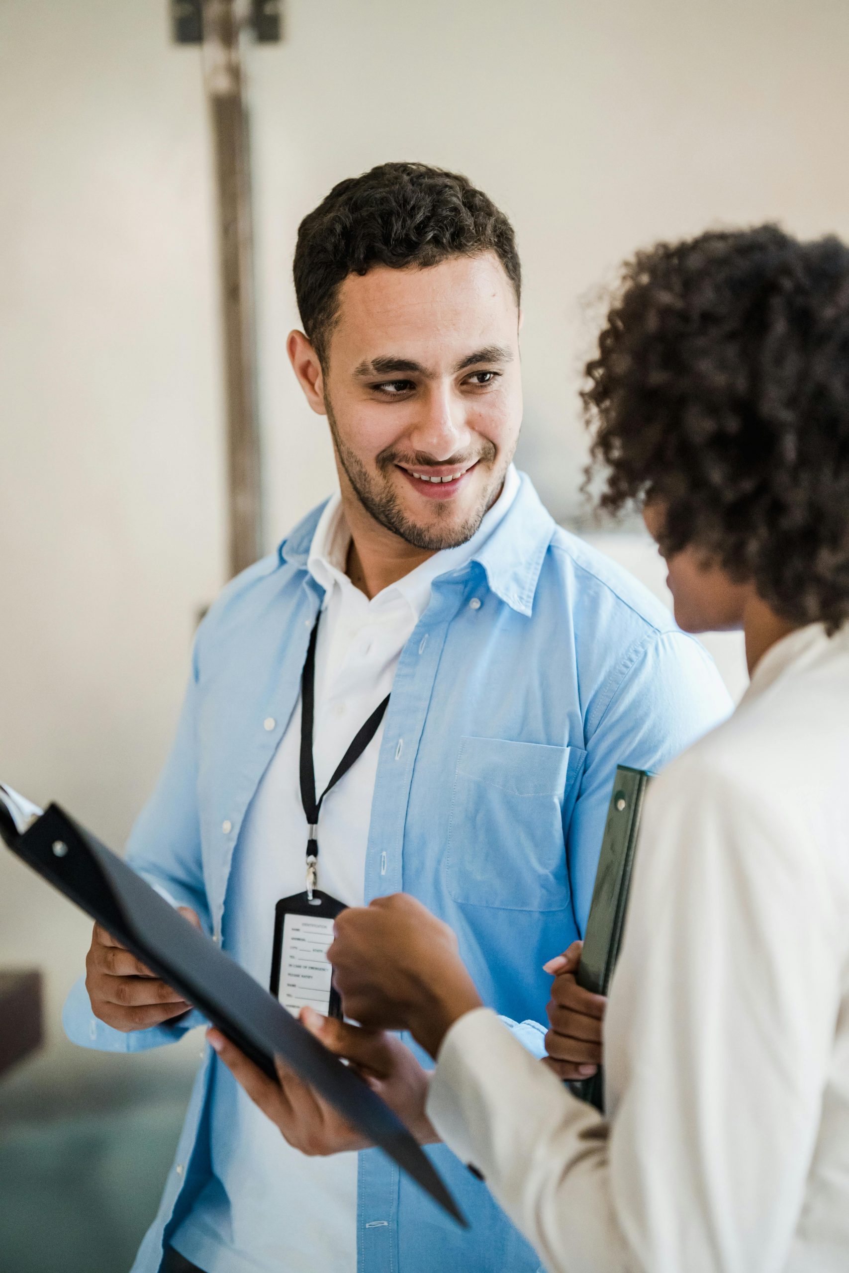 Two people smiling and discussing documents, symbolising collaboration and the step-by-step coaching process for ADHD empowerment.